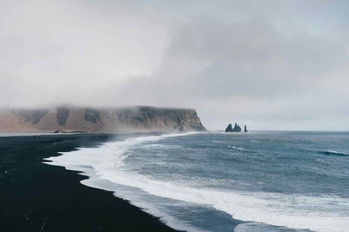 Black sand coast beneath low clouds in Iceland